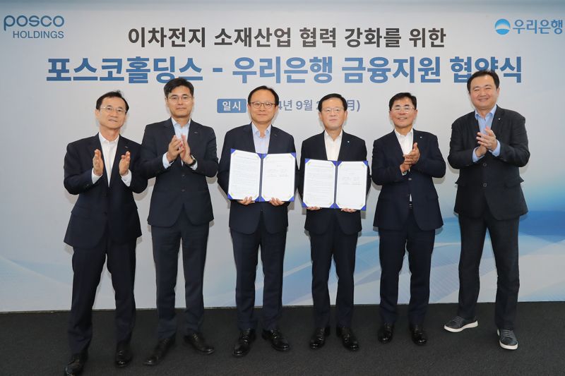 우리은행이 23일 서울 중구 본점에서 포스코홀딩스와 ‘2차전지 핵심소재 경쟁력 강화를 위한 금융지원 업무협약’ 을 체결했다. 정기섭 포스코홀딩스 사장, 조병규 우리은행장(왼쪽 세번째부터)이 관계자들과 기념촬영을 하고 있다. 우리은행 제공