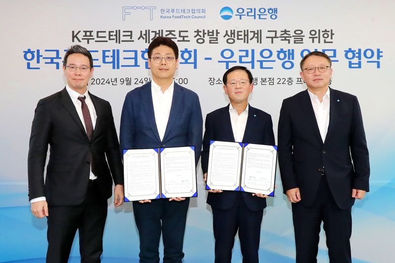 우리은행이 지난 24일 우리은행 본점에서 한국푸드테크협의회와 'K푸드테크 세계주도 창발 생태계 구축을 위한 업무협약'을 체결했다. 신호식 한국푸드테크협의회장, 이기원 한국푸드테크협의회장, 조병규 우리은행장, 정진완 우리은행 중소기업그룹장(왼쪽부터)이 협약식에서 기념사진을 촬영하고 있다. 우리은행 제공