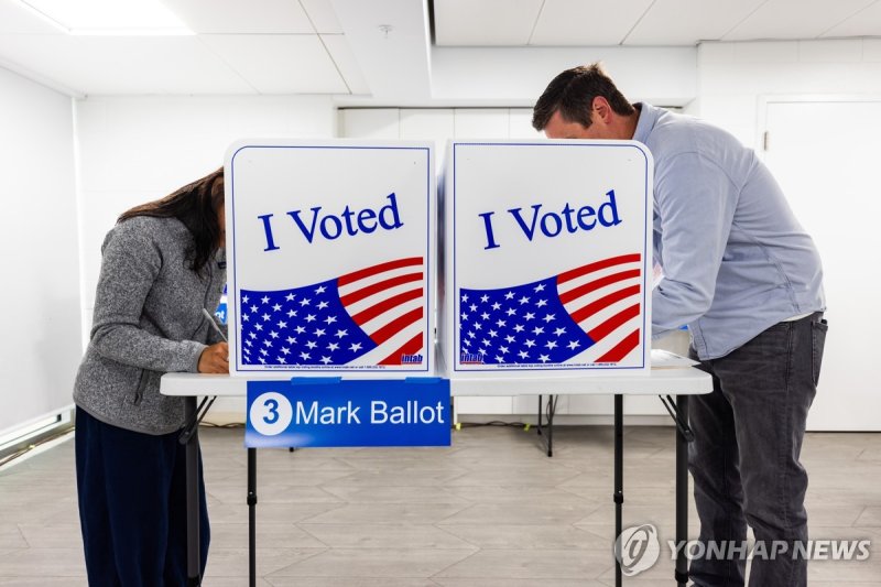 사전투표하는 미국 유권자 epa11622423 Early voters fills in their ballots in the 2024 US presidential election at the Long Bridge Aquatics and Fitness Center in Arlington, Virginia, USA, 24 September 2024. Early in-person voting sites opened throughout Virginia on 20 September 2024. EPA/JIM LO SCALZO