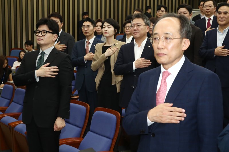 한동훈 국민의힘 대표와 추경호 원내대표가 26일 오전 서울 여의도 국회에서 열린 의원총회에서 국기에 경례를 하고 있다. 뉴스1