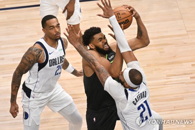 공격하는 칼앤서니 타운스 epa11380890 Minnesota Timberwolves center Karl-Anthony Towns (C) goes up for a shot between Dallas Mavericks center Daniel Gafford (R) and Dallas Mavericks forward P.J. Washington (L) during the third quarter of game five of the NBA Western Conference finals between the Dallas Maverick