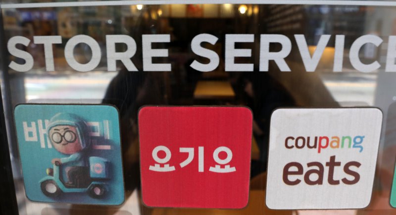 서울 강서구의 한 음식점 앞에 붙어 있는 에어카지노의 민족, 요기요, 쿠팡이츠 스티커(왼쪽부터). 뉴시스