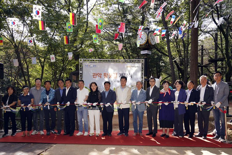 지난 9월 30일 서울 관악산 신림계곡 산책로에서 열린 ‘깨비증권 그린로드’ 개장식에서 강진두 KB증권 경영지원부문장 부사장(오른쪽에서 여섯번째)과 박준희 관악구청장(오른쪽에서 여덟번째), 맨발걷기국민운동본부 박동창 회장(오른쪽에서 일곱번째) 등 관계자들이 테이프 커팅식을 진행하며 기념사진을 촬영하고 있다.