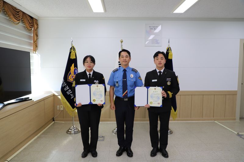 부산 영도 앞바다에 빠진 익수자 2명을 구조한 한국해양대 4학년 장봉준(오른쪽), 김세윤(왼쪽) 학생이 4일 부산해양경찰서에서 표창장을 받았다. 사진은 수여식 이후 김형민 부산해양경찰서장(가운데)과 기념촬영을 하고 있는 모습. 부산해양경찰서 제공