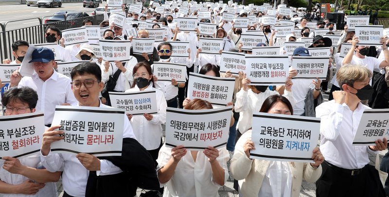 지난 3일 오후 서울 용산구 대통령실 앞에서 열린 '의학교육평가원 무력화 저지를 위한 전국의과대학 교수 결의대회'에서 참가자들이 구호를 외치고 있다. 사진=뉴시스