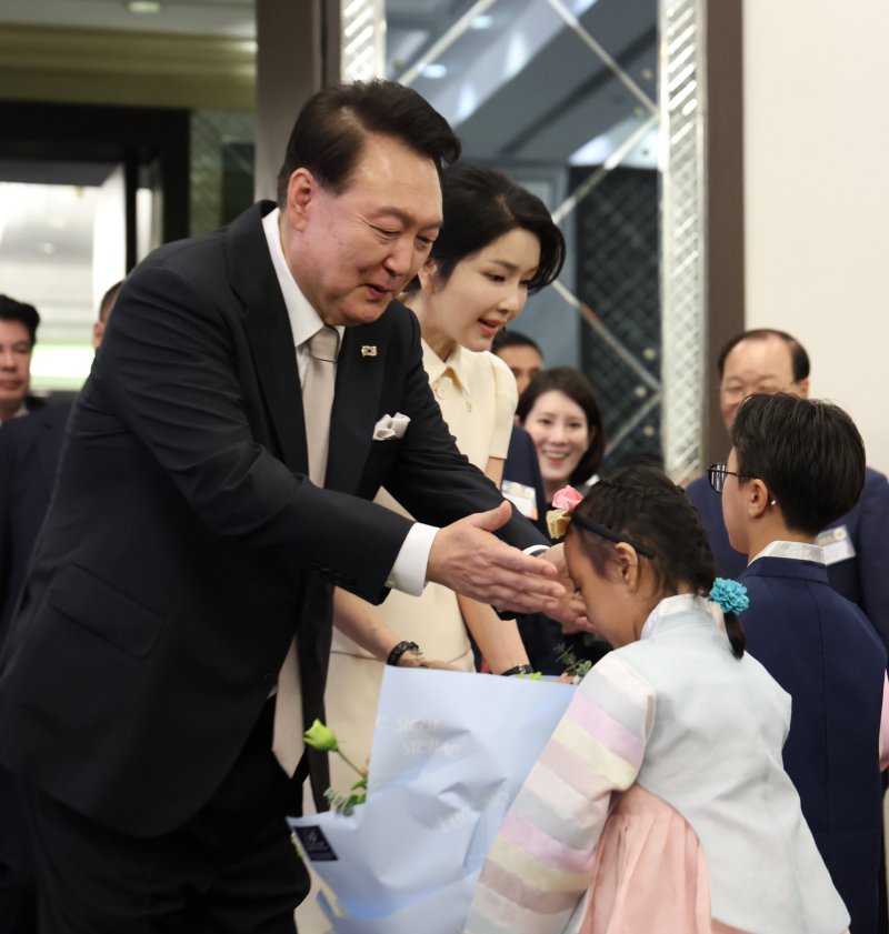 필리핀을 국빈 방문한 윤석열 대통령과 김건희 여사가 6일 오후(현지시간) 필리핀 마닐라 페닌슐라 호텔에서 열린 동포 만찬 간담회에 참석해 화동으로부터 꽃다발을 받고 있다. 사진=연합뉴스