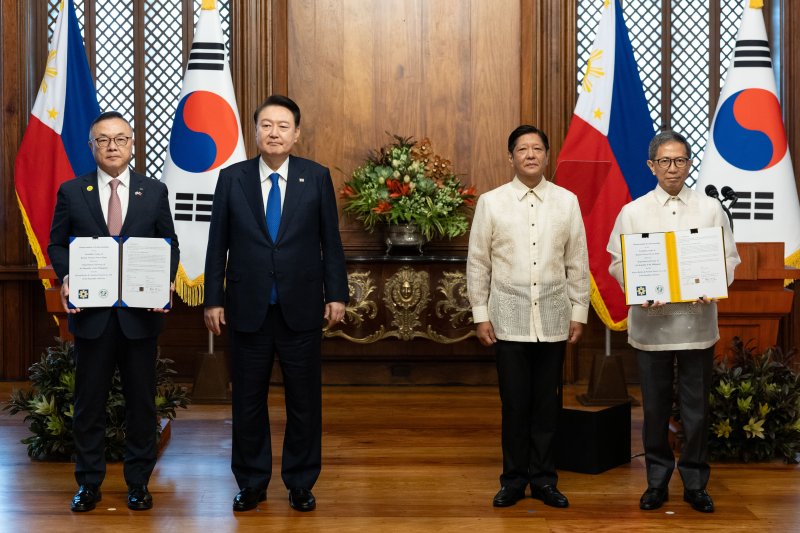 황주호 한국수력원자력 사장과 라파엘 로띨리야 필리핀 에너지부 장관이 7일 오전(현지시간) 필리핀 마닐라 말라카냥 대통령궁에서 윤석열 대통령과 페르디난드 마르코스 필리핀 대통령이 임석한 가운데 한·필리핀 바탄 원전 건설 재개 타당성 조사 협력에 관한 양해각서(MOU)를 교환한 뒤 기념촬영을 하고 있다. 사진=연합뉴스