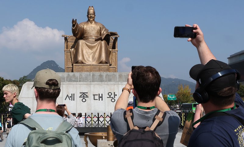 지난 8일 오후 서울 광화문 광장을 찾은 외국인 관광객들이 세종대왕 동상을 사진 찍고 있다. 뉴스1