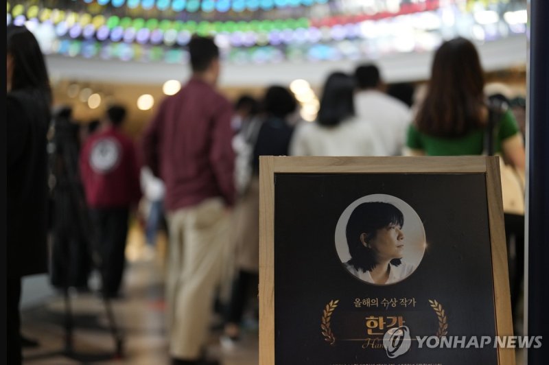 NYT, 한국 첫 노벨문학상 '여성' 주목…"가부장 문화에 저항" A picture of South Korean poet and novelist Han Kang, who won the Nobel Prize in literature, is displayed as people gather to buy books near a special section for her at a bookstore in Seoul, South Korea, Friday, Oct. 11, 2024. (AP Photo/Lee Jin-man)