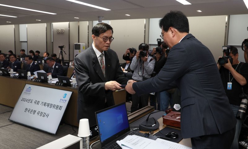 이창용 한국은행 총재가 14일 서울 중구 한국은행 본부에서 열린 국회 기획재정위원회의 한국은행에 대한 국정감사에 출석해 증인 선서를 마친 뒤 송언석 기재위원장에게 선서문을 제출하고 있다. 뉴시스.