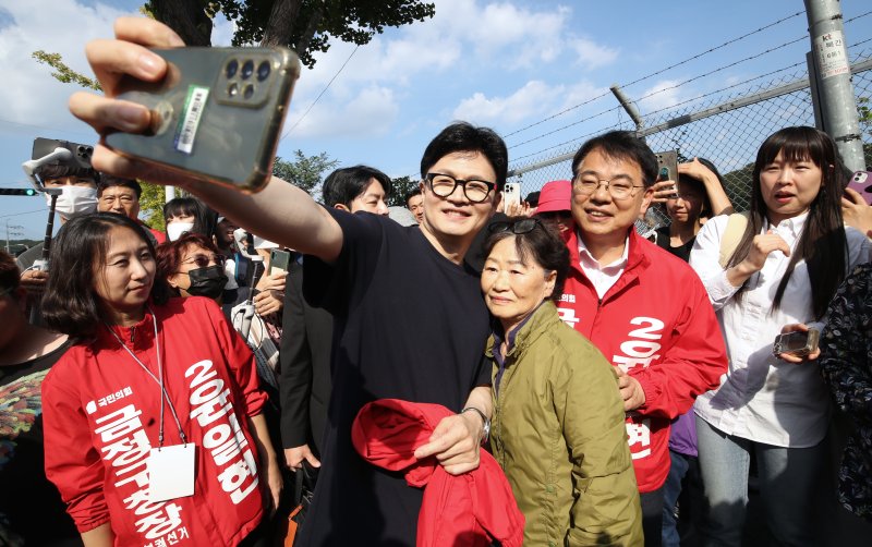 한동훈 국민의힘 대표가 12일 오후 부산 금정구 노포역 일대에서 시민들에게 윤일현 금정구청장 후보에 대한 지지를 호소하며 셀카를 찍고 있다. 2024.10.12/뉴스1 ⓒ News1 윤일지 기자