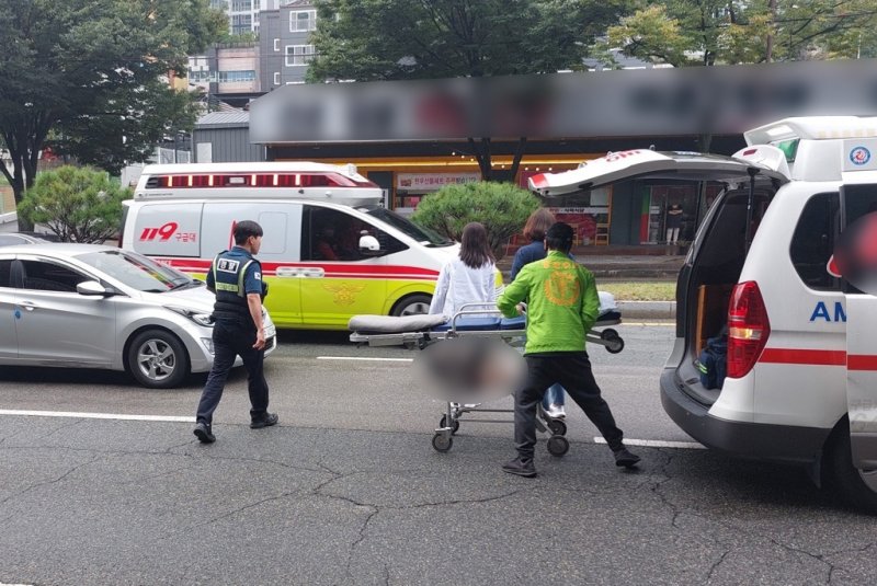 15일 오전 김해에서 열린 전국체전 하프마라톤 경기에서 통제구간에 진입한 승용차가 경기 중인 선수를 뒤에서 들이 받아 부상을 입은 선수가 병원으로 이송되고 있다. /사진=연합뉴스