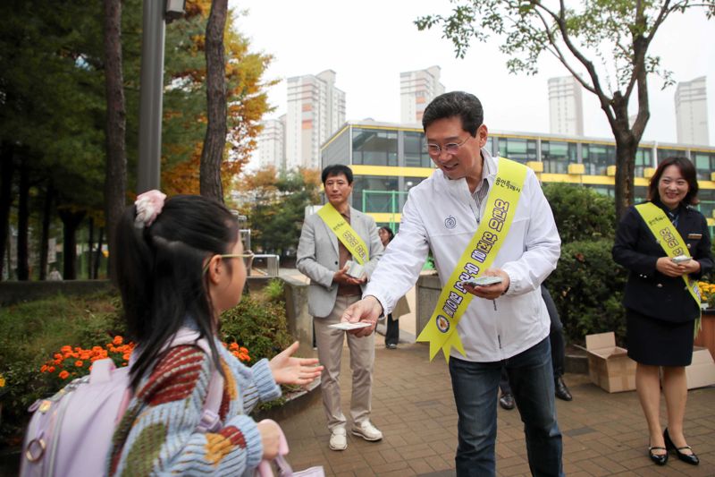 이상일 용인시장이 15일 수지구 신봉초등학교를 찾아 혼잡한 등굣길 환경을 점검하고, 교통안전 캠페인에 참여했다. 용인시 제공