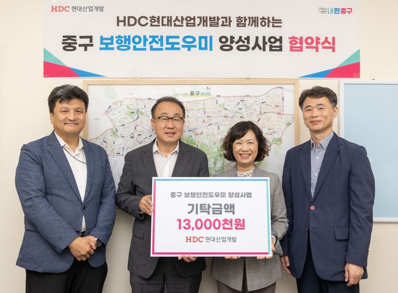 신왕섭 HDC현대산업개발 실장(가운데), 김남희 중구 경제문화국장(오른쪽)이 16일 서울 중구청에서 협약식을 열고 보행안전도우미 양성을 위한 업무협약을 체결했다. HDC현대산업개발 제공