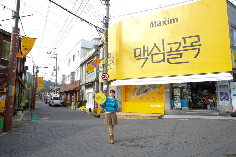 동서식품이 다음달 17일까지 전북 군산시 월명동에 운영하는 ‘맥심골목’을 모델이 가리키고 있다. 동서식품 제공