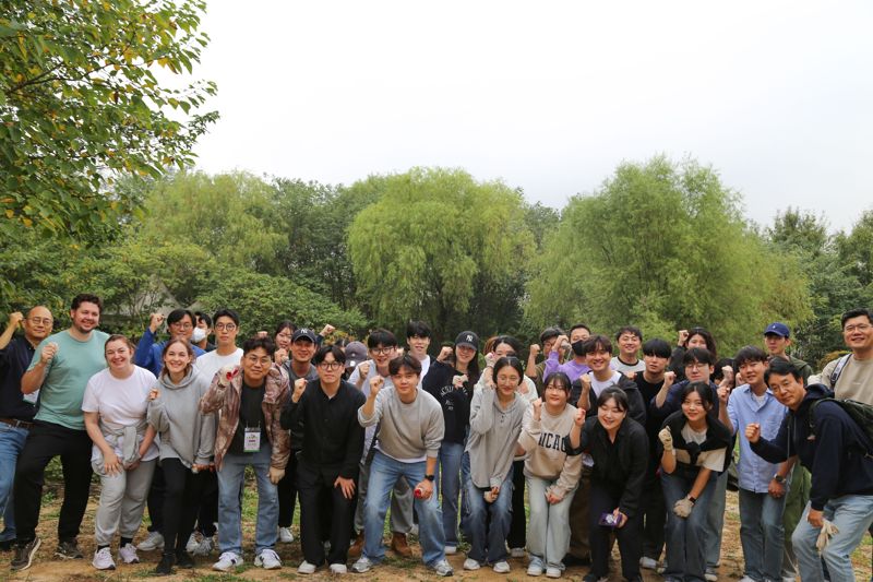 지난 15일 서울 마포구 노을공원에서 DL이앤씨 직원들이 도토리 나무심기 행사 후 기념촬영을 하고 있다. DL이앤씨 제공