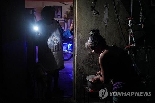 쿠바에서 전국적인 정전 사태가 발생하면서 한 여성이 휴대전화로 불빛을 밝히고 있다. AFP연합뉴스