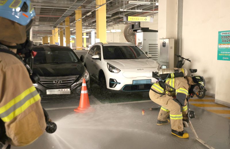 지난 21일 오후 경기도 고양시 고양아람누리에서 진행된 다중밀집시설 대형화재를 대비한 '2024년 고양특례시 재난대응안전한국훈련'에서 소방대원들이 지하주차장에서 화재가 발생한 전기차량을 상방향 방수장치로 진화 하고 있다. 뉴시스