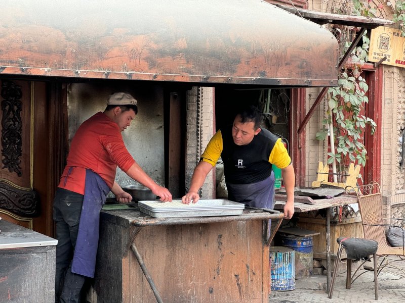 [우루무치=뉴시스] 문예성 기자= 중국 신장위구르자치구 카스 구시가지의 한 가게에서 2명의 남성이 지난 17일 위구르족 주식인 낭(화덕에 구운 납작한 밀가루 빵)을 만들고 있다. 중국어로 ‘카스고성’이라고도 불리는 구시가지는 카스 내 3.6㎢의 지역으로 위구르족 주민들이 2000년 넘게 모여 살면서 이슬람 문화와 전통을 보존한 곳이다. 위구르족 문화를 체험할 수 있어 신장에서는 물론 전국적으로 인기 있는 관광지이기도 하다 2024.10.21 sophis731@newsis.com