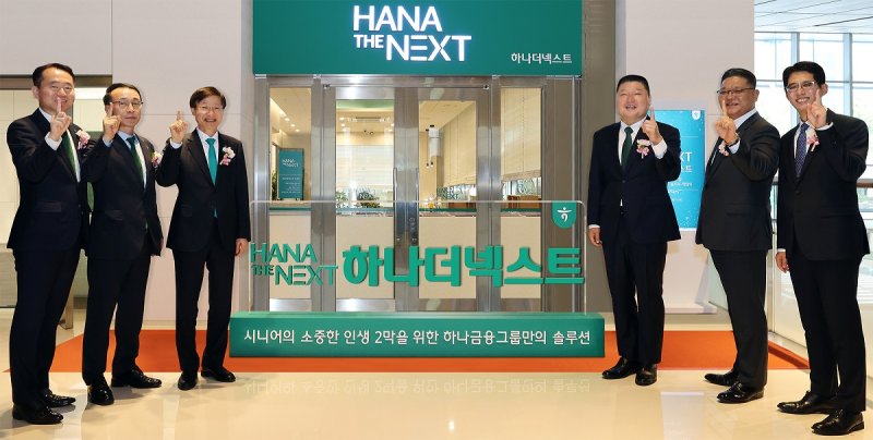 하나금융그룹은 그룹의 시니어 특화 브랜드 '하나 더 넥스트(HANA THE NEXT)'를 출범하고, 시니어 세대의 성공적인 노후를 위한 특화 서비스를 시행한다고 22일 밝혔다. 이승열 하나은행장(왼쪽 세 번째)과 '하나 더 넥스트'의 광고모델 방송인 강호동(오른쪽 세 번째)이 하나은행 임직원과 함께 그룹 시니어 특화 브랜드 '하나 더 넥스트'의 출범을 알리는 현판식 진행 후 기념촬영을 하고 있다. 하나금융 제공