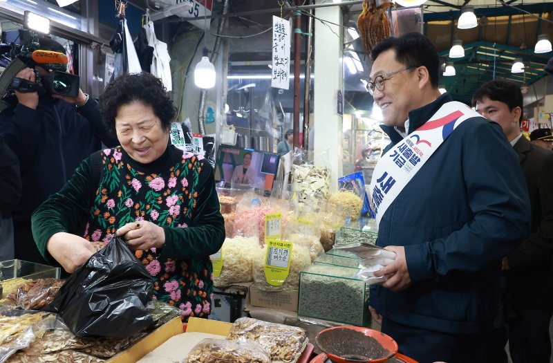 김병환 금융위원회 위원장(오른쪽)이 22일 소상공인·자영업자 지원 프로그램인 '새출발기금' 홍보활동을 위해 경기 안양중앙시장을 방문, 상인과 대화를 나누고 있다. 금융위원회 제공