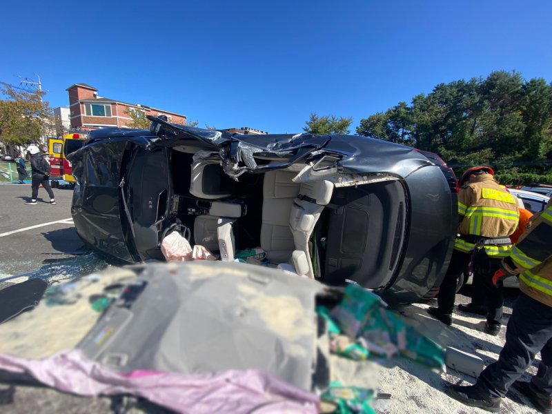 23일 울산 중구 성안동의 한 주차장에서 70대가 몰던 SUV 차량이 주차 차량과 충돌 후 옆으로 넘어져 있다. 119 구조대가 차량 지붕을 뜯어낸 뒤 운전자를 구조했다. 울산경찰청 제공