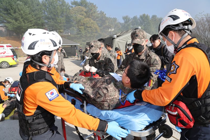 24일 오후 경기 포천시 승진훈련장 일대에서 열린 '2024 재난대응 안전한국훈련'에서 장병들 및 포천소방서 대원들이 환자 응급처치 및 후송을 하고 있다. 사진=국방일보 제공