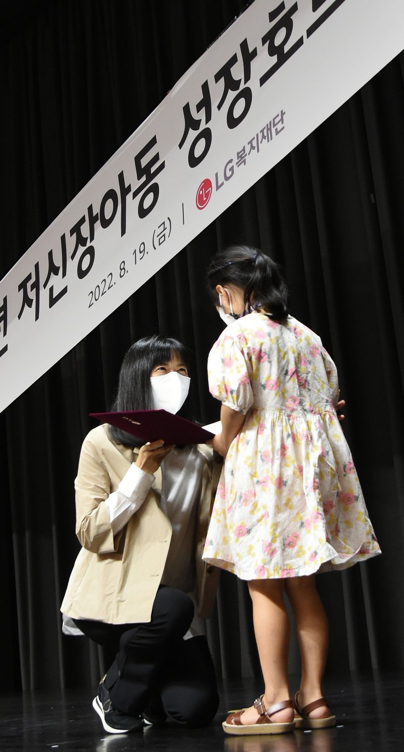 [서울=뉴시스] 서울 마곡 LG사이언스파크에서 진행된 '저신장아동 성장호르몬제 기증식'에서 구연경 LG복지재단 대표이사(왼쪽)가 어린이에게 기증서를 전달하고 있다.(사진=LG 제공) 2022.08.22. photo@newsis.com *재판매 및 DB 금지