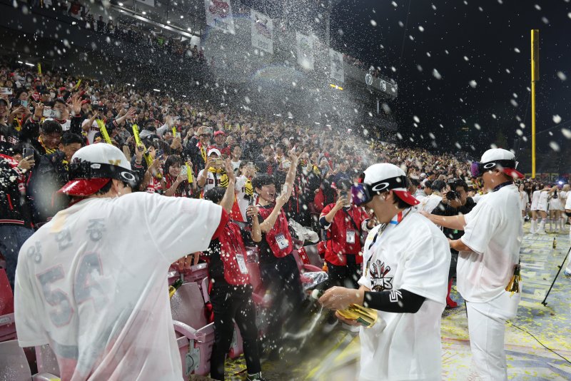 28일 오후 광주 기아챔피언스필드에서 열린 프로야구 '2024 신한 SOL 뱅크 KBO 포스트시즌' 한국시리즈 5차전 삼성 라이온즈와 KIA 타이거즈의 경기에서 7대5로 승리하며 시리즈 전적 4대1로 통합 우승을 차지한 KIA 선수들이 팬들에게 샴페인을 뿌리고 있다. 2024.10.28/뉴스1 ⓒ News1 장수영 기자