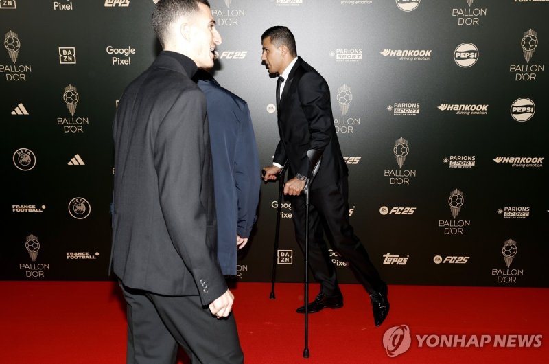 목발을 짚고 발롱도르 행사에 참석한 로드리 epa11689388 Spain and Manchester City midfielder Rodri arrives on crutches for the Ballon d'Or 2024 ceremony at the Theatre du Chatelet in Paris, France, 28 October 2024. EPA/MOHAMMED BADRA