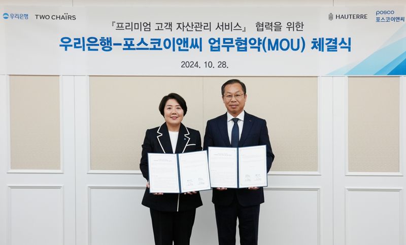 우리은행이 지난 28일 인천 포스코이앤씨 송도사옥에서 고액자산가 특화서비스 확대를 위한 업무협약을 맺었다. 송현주 우리은행 자산관리그룹장(왼쪽)과 정희민 포스코이앤씨 건축사업본부 부사장이 기념촬영을 하고 있다. 우리은행 제공