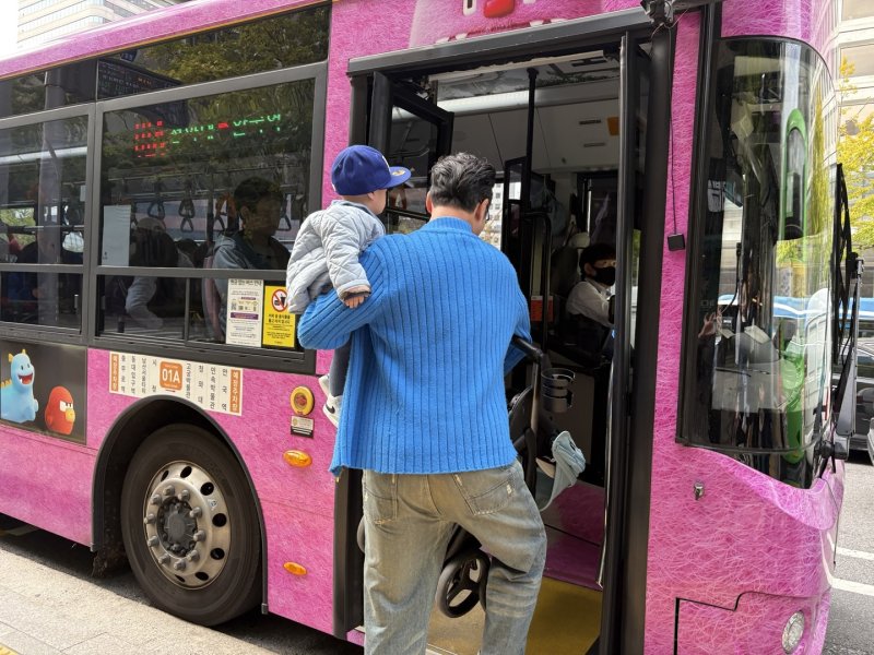 배 씨가 유아차와 아이를 들고 버스를 타는 모습.