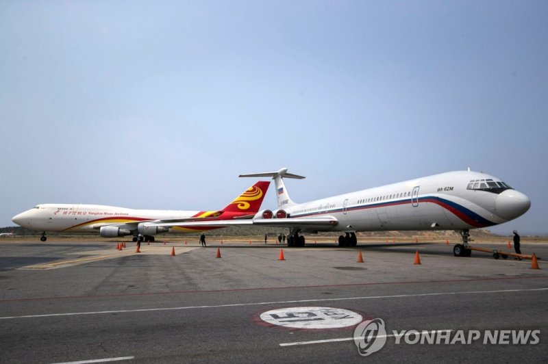 러 공군기, 北 들러 우크라 접경지행…"군사 관리들 실어나른듯" epa07472145 A Suparna Airlines Boeing 747-400 airplane (Tail number B-2435) (L) arrives from China with medical materials at the Simon Bolivar International Airport as a Russian Air Force Ilyushin Il-62M aircraft (Tail number RA-86496), in Maiquetia, near Caracas,