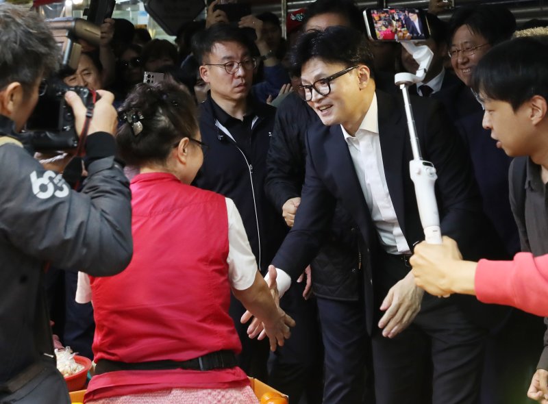 한동훈 국민의힘 대표가 23일 오후 부산 금정구 서동미로시장을 찾아 윤일현 금정구청장과 함께 상인들에게 당선 감사 인사를 하고 있다. 2024.10.23/뉴스1 ⓒ News1 윤일지 기자