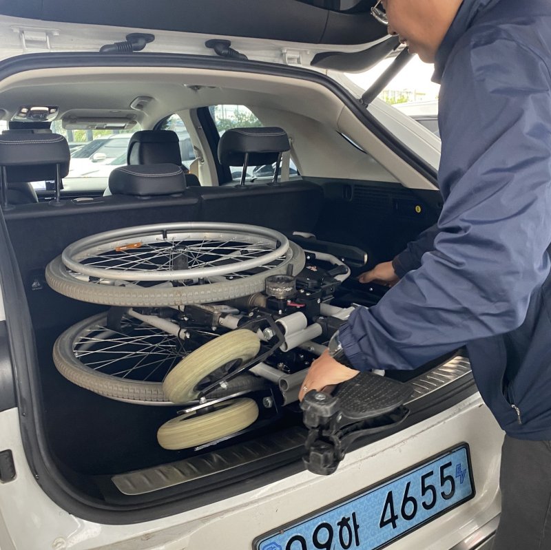 SK렌터카 제주지점에서 차량 대여 시 무료로 대여 가능한 수전동 휠체어를 직원이 차량에 싣고 있는 모습(SK렌터카 제공)