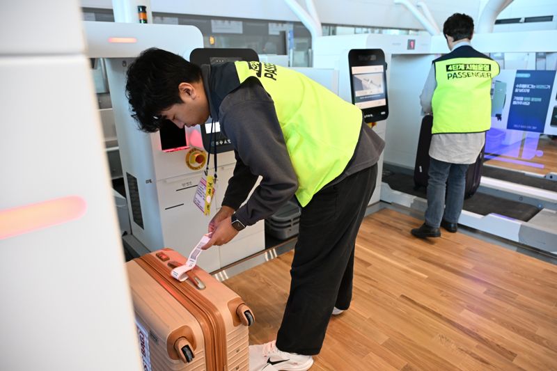 30일 인천국제공항 제2여객터미널 확장 지역에서 실시된 4단계 시설 개장 준비상황 점검 훈련에 참가한 가상 여객들이 항공기에 탑승하기 위해 셀프 보딩 시스템을 통해 신원을 확인하고 있다. 사진=박범준 기자