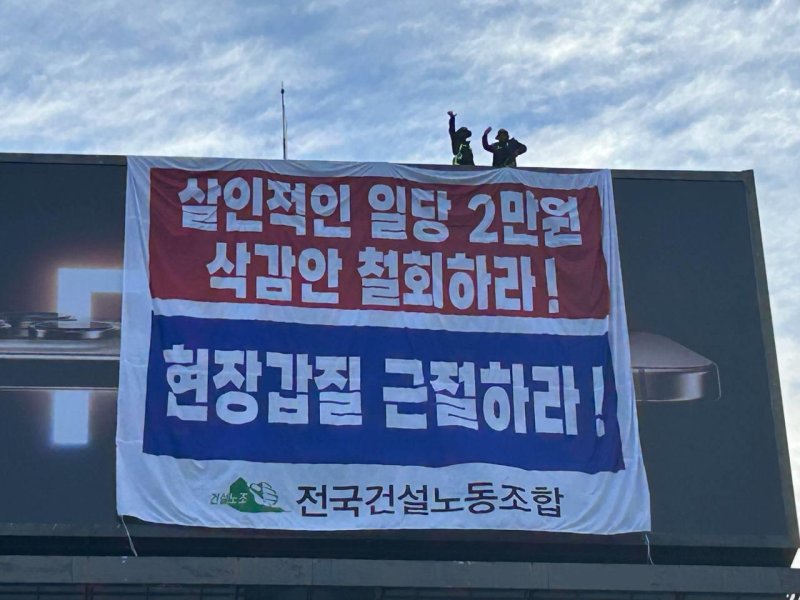 지난달 2일 임금 협상 체결을 촉구 집회를 앞두고 건설 노동자 2명이 30m 높이의 광고탑에 올라가 농성을 벌이고 있다. 건설노조 제공