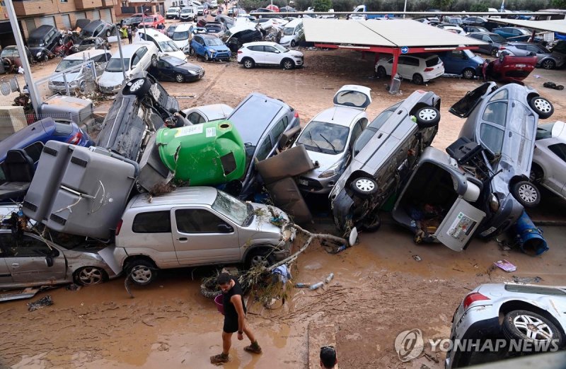 홍수에 휩쓸려 쌓인 차량 Wreckage of cars and debris are piled up in the streets of Paiporta, on October 31, 2024, covered in mud after flash floods ravaged this area of Valencia region, eastern Spain. Rescuers raced on October 31, 2024 to find survivors and victims of once-in-a-generation floods in Spain that