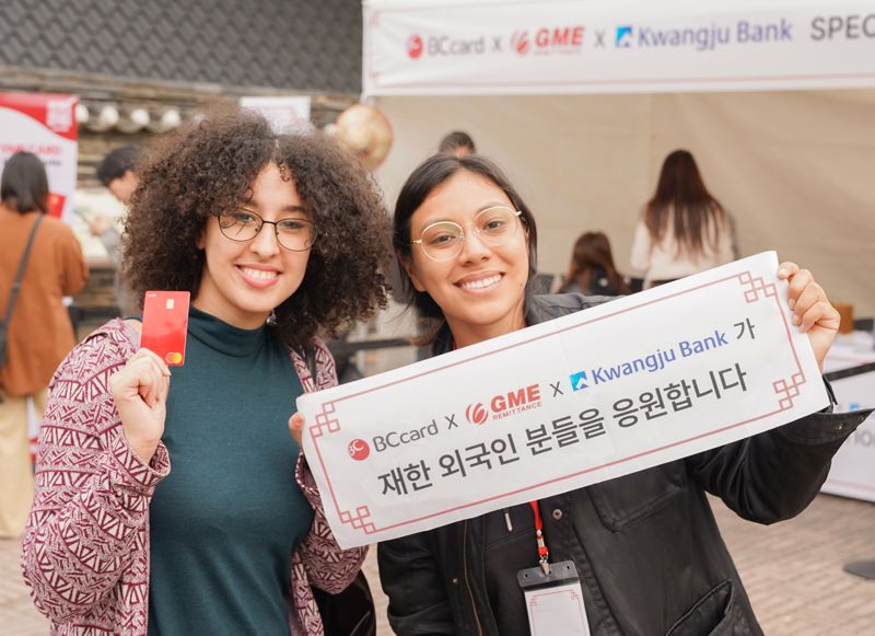 지난 1일 경기도 용인 한국민속촌을 방문한 외국인 관광객들이 BC카드, 광주은행, 글로벌머니익스프레스가 준비한 미니 현수막을 들고 기념촬영을 하고 있다./사진=BC카드