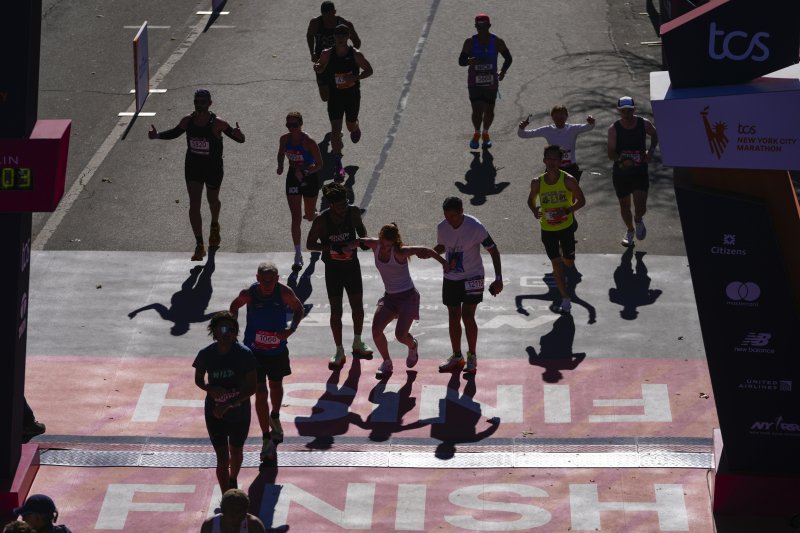 [뉴욕=AP/뉴시스] 3일(현지시각) 미국 뉴욕에서 제54회 뉴욕 마라톤이 열려 한 참가자가 다른 참가자들의 도움을 받으며 결승선으로 들어오고 있다. 세계 6대 마라톤 중 하나인 뉴욕 마라톤은 매년 11월 첫째 일요일에 열린다. 2024.11.04.