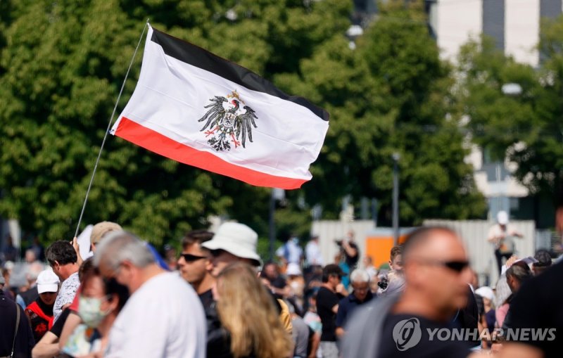 독일제국 국기 epa08426223 A man holds a flag of the German Empire with the Imperial Eagle coat of arms during a demonstration of the initiative 'Lateral thinking' in Stuttgart, Germany, 16 May 2020. A series of demonstrations are held throughout Germany, calling for ending of the social and economical res