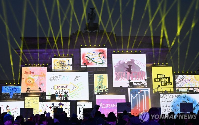 베를린 장벽 옛 터에 세워진 자유를 희구하는 구조물 The Brandenburg gate is illuminated during celebrations marking the 35th anniversary of the fall of the Berlin Wall in Berlin on November 9, 2024. Germany on Saturday celebrates 35 years since the fall of the Berlin Wall ushered in the end of communism and national reuni