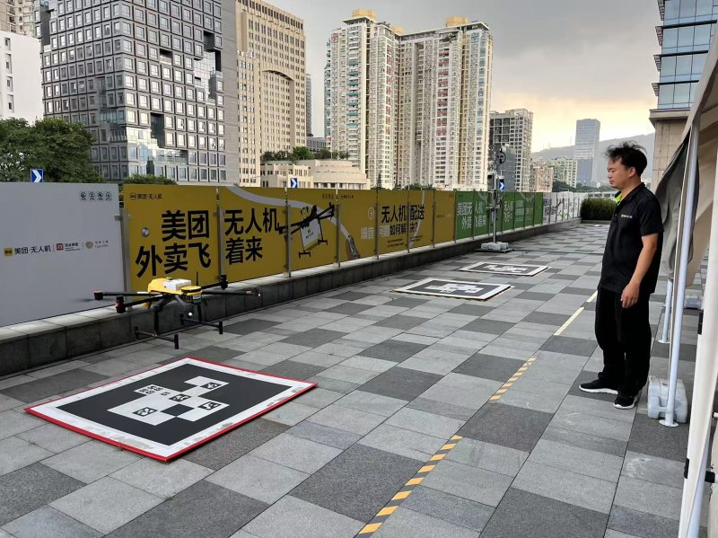 메이퇀의 한 직원이 배송을 마치고 도착하는 배달 드론을 바라보고 있다. 사진=이석우 기자