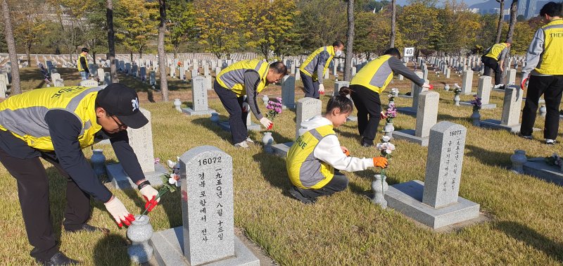 한신공영 한신효(孝)플러스봉사단 임직원 및 가족들이 지난 9일 서울 동작구 국립서울현충원에서 묘역 정화 봉사활동을 진행하고 있다. 한신공영 제공