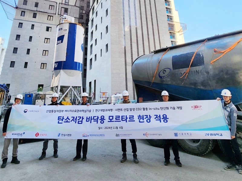 지난 6일 롯데건설 직원들이 '이산화탄소 주입 바닥용 모르타르' 기술을 현장에 적용한 뒤 기념촬영을 하고 있다. 롯데건설 제공