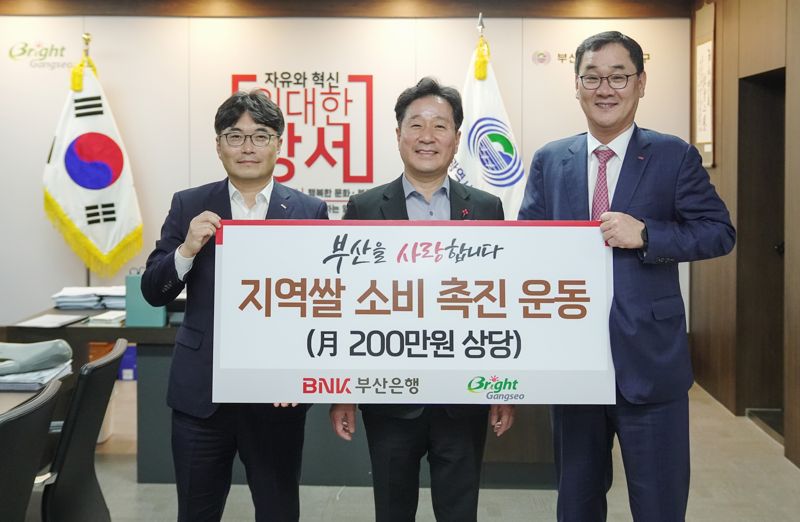 BNK부산은행 이상룡 서부·경남영업본부장(오른쪽)이 지역 쌀 소비 촉진 운동에 동참할 것을 약속하고, 부산시 김형찬 강서구청장(가운데)과 기념사진을 촬영하고 있다. 부산은행 제공