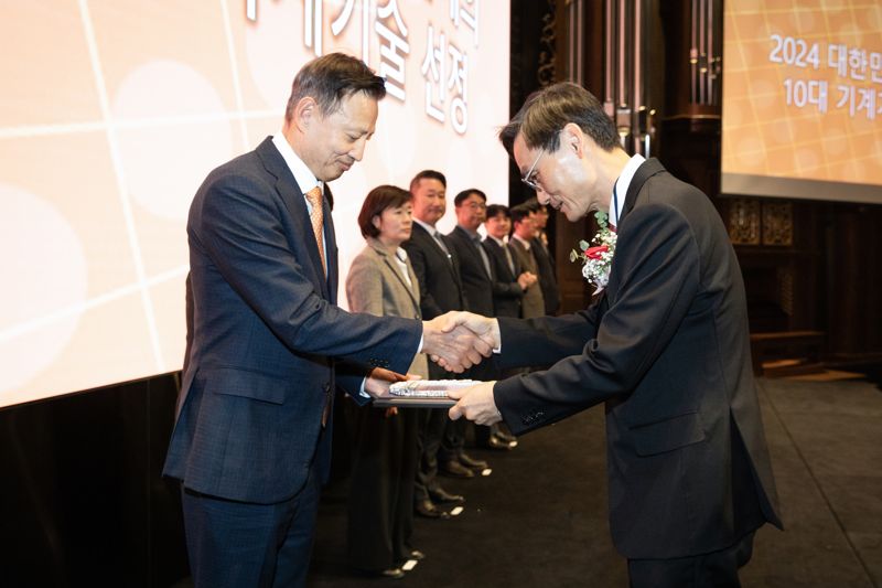 이광열 두산에너빌리티 전무(앞줄 왼쪽)가 13일 서울 엘타워에서 진행된 '2024 올해의 10대 기계기술' 시상식에서 김동환 대한기계학회 학회장 건네는 상패를 받고 있다. 두산에너빌리티 제공