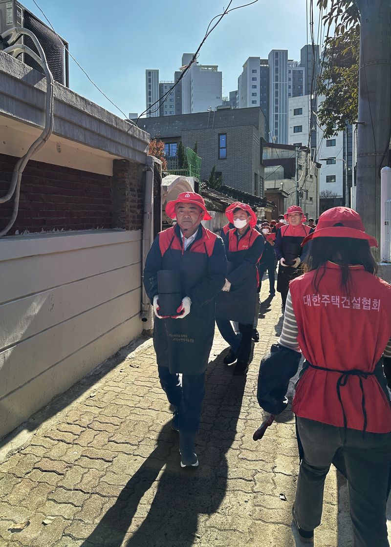 13일 서울 동작구 일대에서 대한주택건설협회 정원주 회장(왼쪽 첫 번째)이 사랑의 연탄나눔 봉사활동에 참여해 구슬땀을 흘리고 있다.