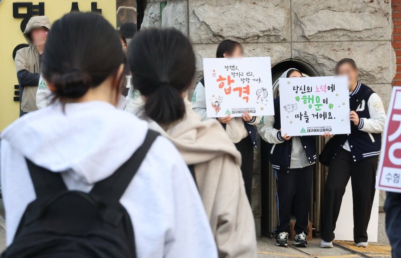 14일 서울 중구 남산고등학교로 수험생들이 응원을 받으며 입실하고 있다. 연합뉴스