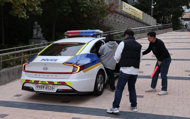 2025학년도 대학수학능력시험일인 14일 오전 서울시교육청 12지구 제22시험장인 서울 마포구 홍익대학교사범대학부속여자고등학교에서 한 수험생이 경찰차에 탑승해 시험장으로 향하고 있다. 뉴스1